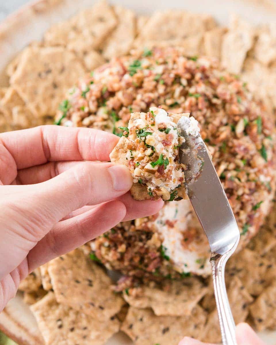 spreading ranch bacon cheese ball on a cracker