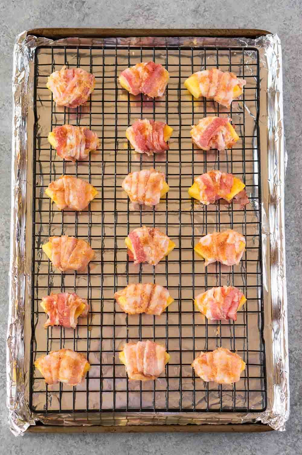 Bacon wrapped pineapple bites on a sheet