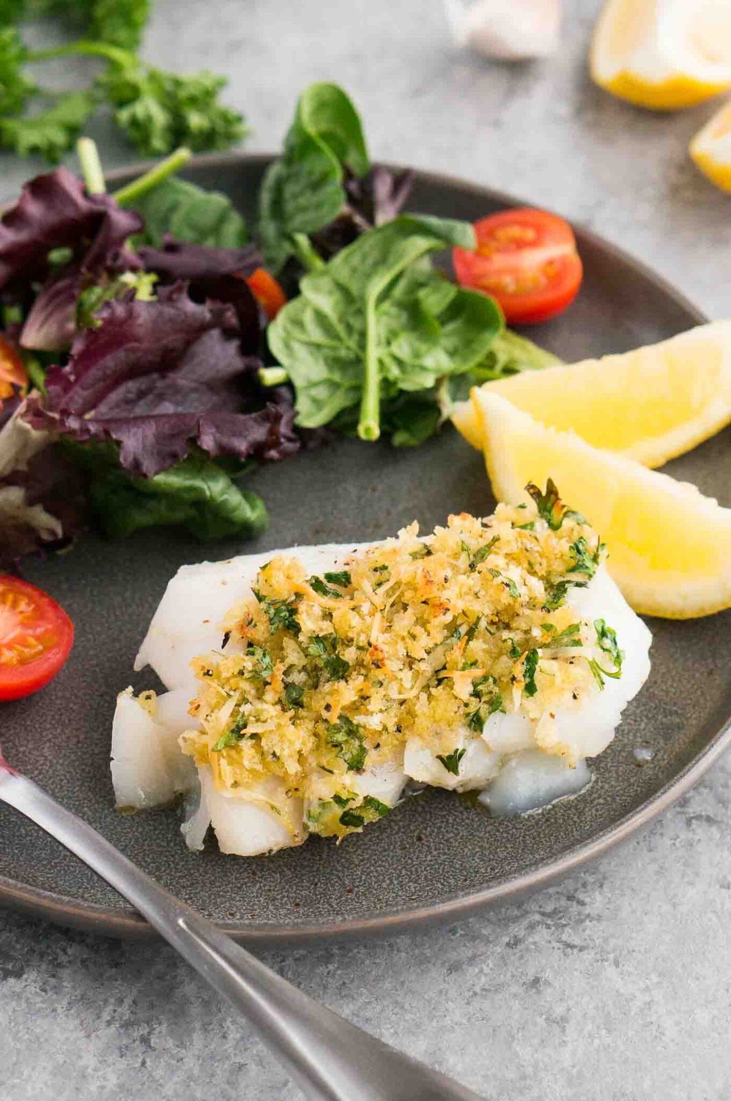 oven baked cod with gremolata on a plate with salad