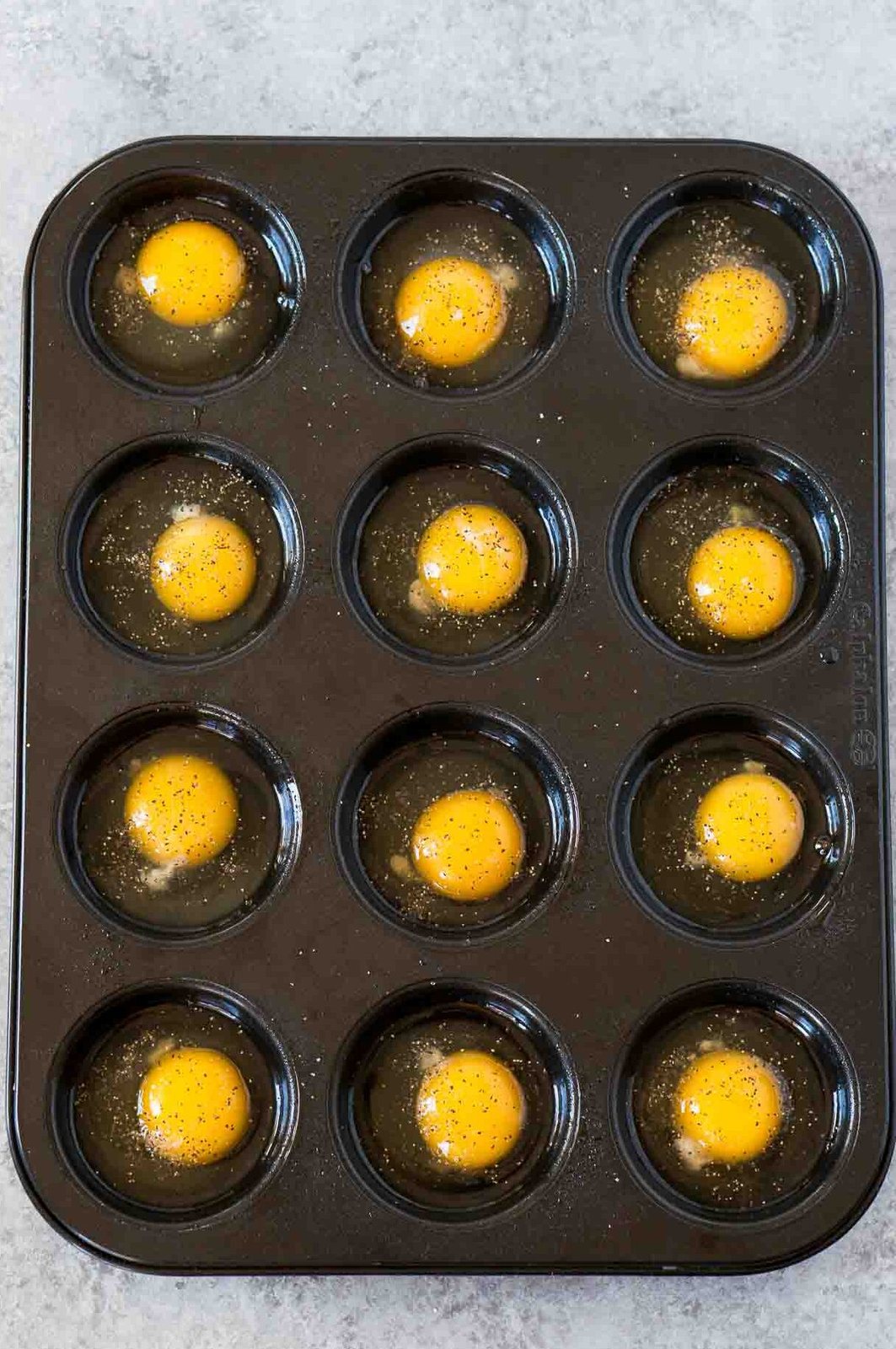 12 cracked eggs in a muffin tin