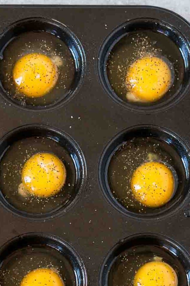 cracked eggs in a muffin tin