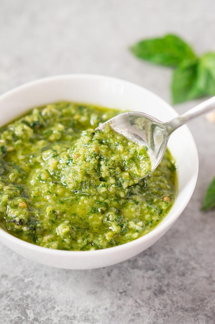 creamy homemade pesto sauce in a bowl with a spoon