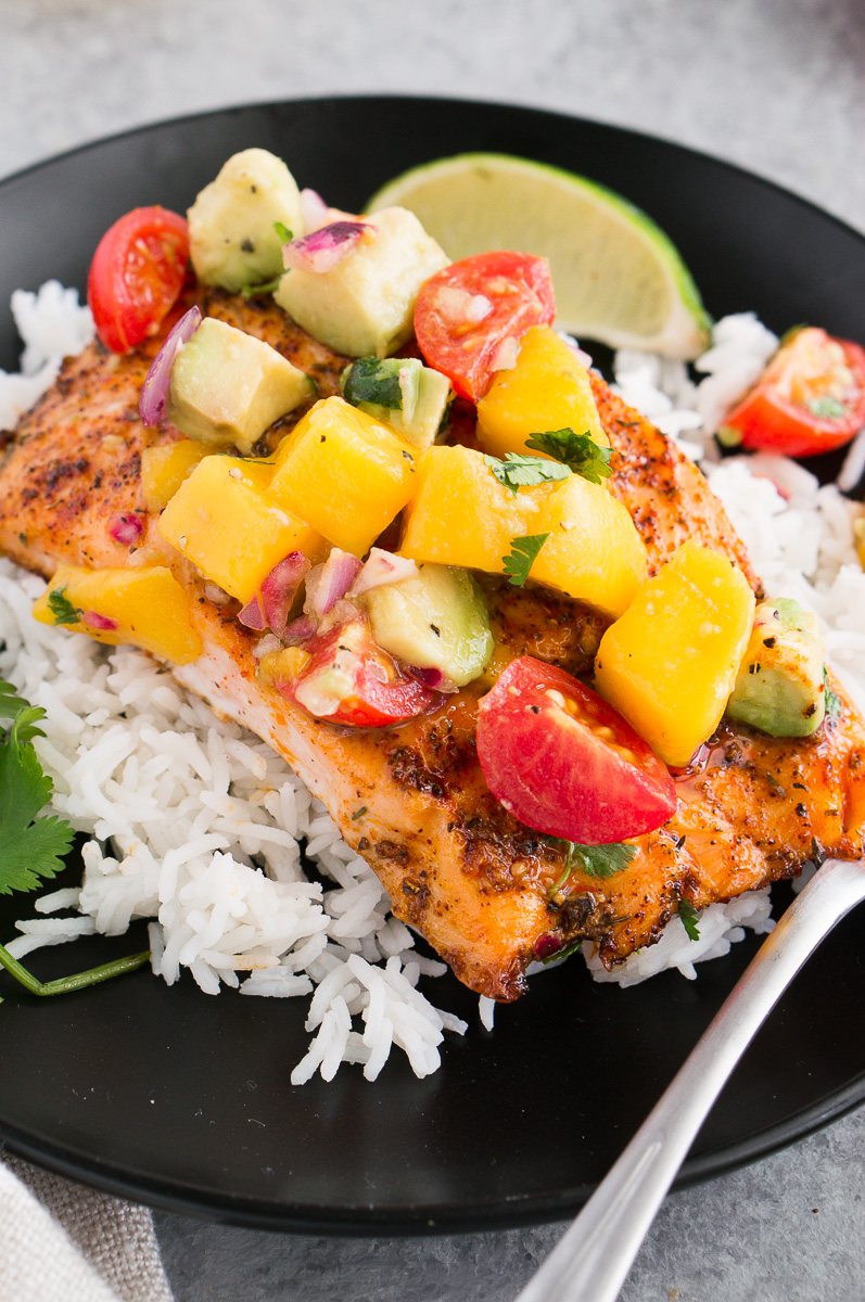 close up image of salmon with avocado mango salsa