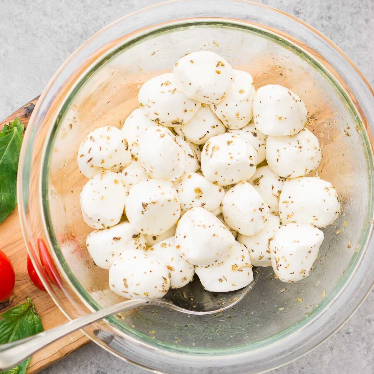 mozzarella balls marinated with olive oil and herbs in a bowl