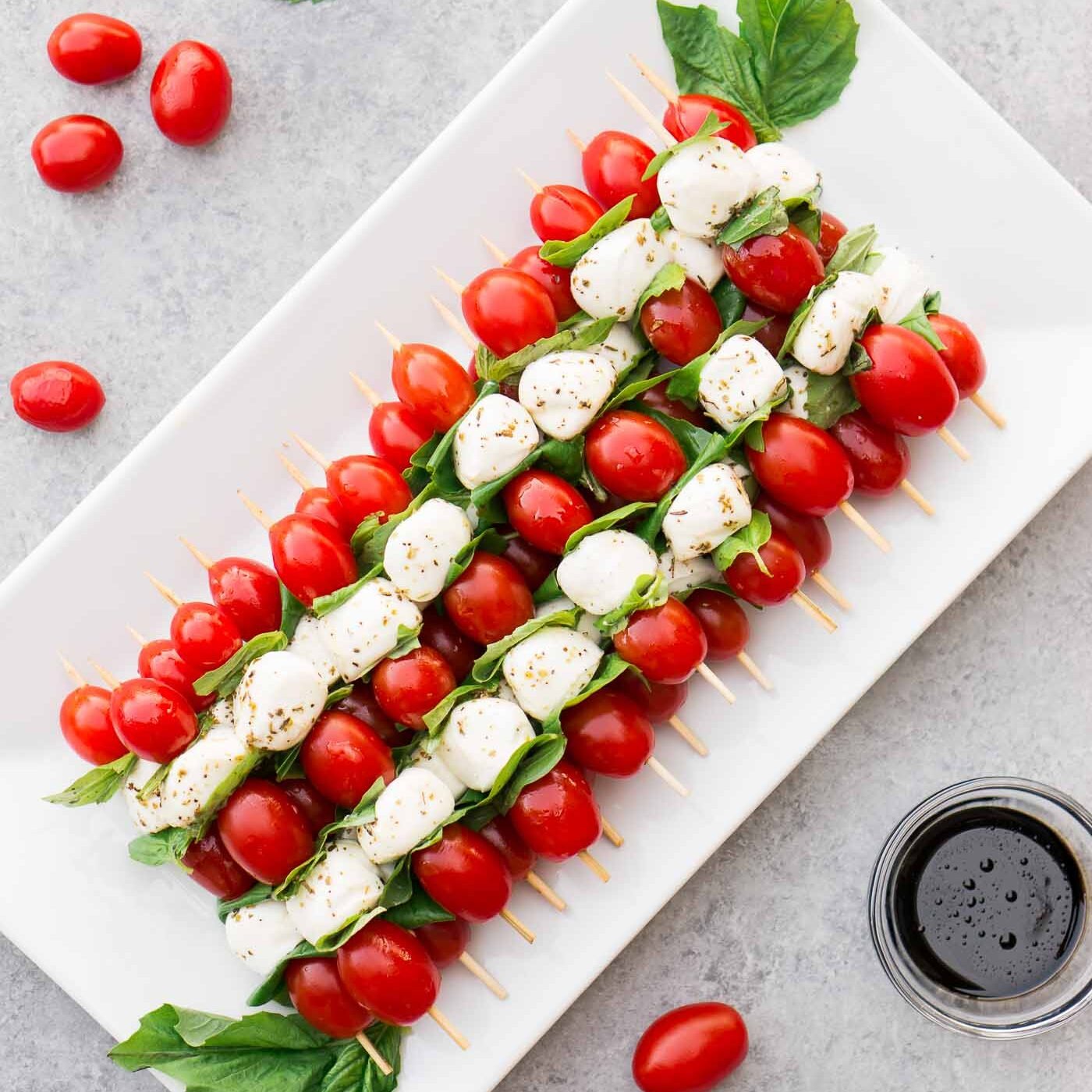 stacked caprese salad skewers on a platter