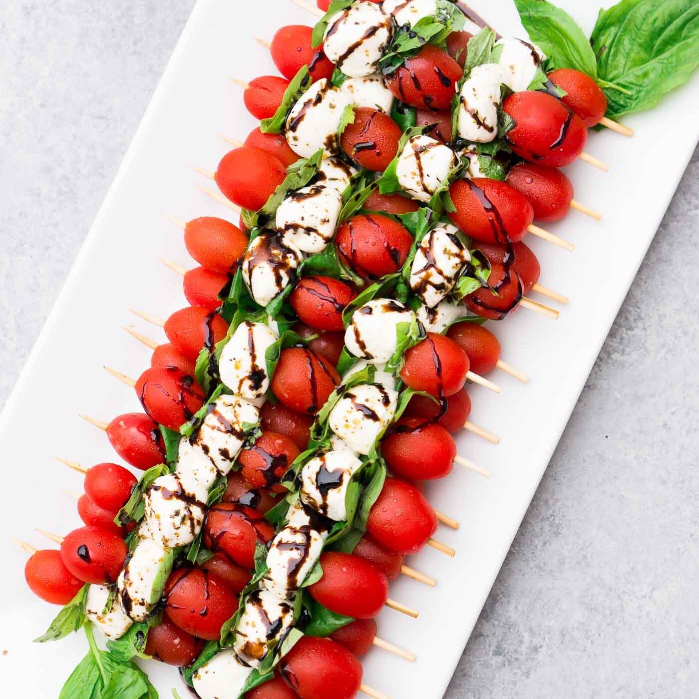 caprese skewers appetizer drizzled with balsamic glaze on a platter