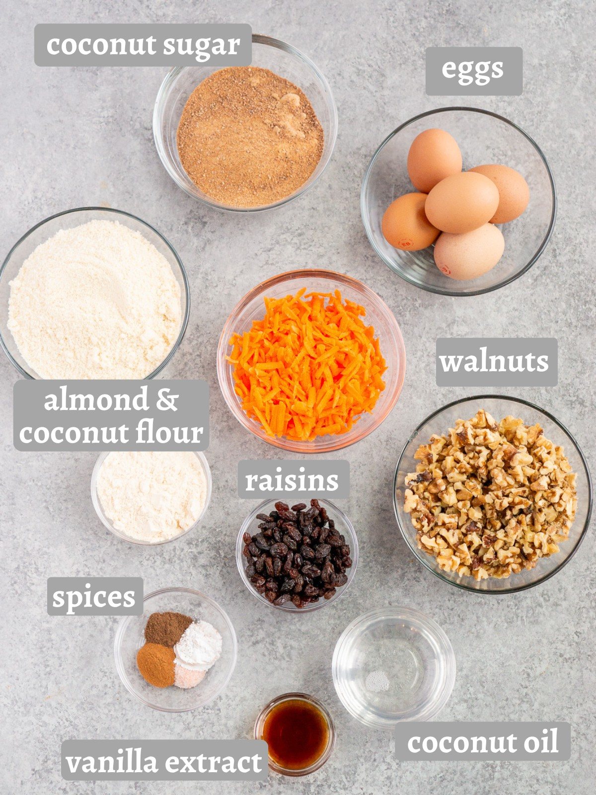 ingredients for carrot cake bars including carrots, gluten-free flour blend, walnuts, raising, eggs and spices