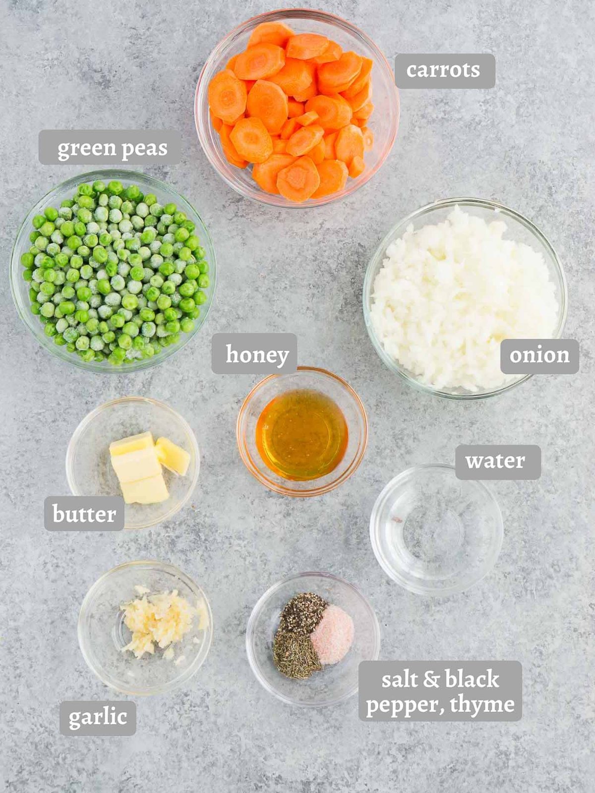 ingredients for carrots and peas recipe including carrots, frozen peas, honey, butter, garlic, and onion