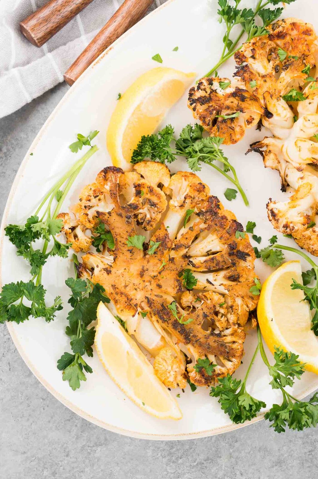 cauliflower slices and lemon wedges on a plate