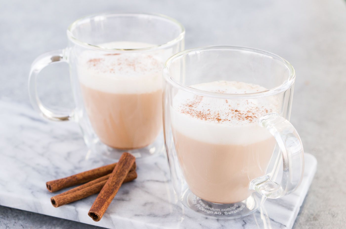 Homemade chai tea latte topped with milk foam in glass cups