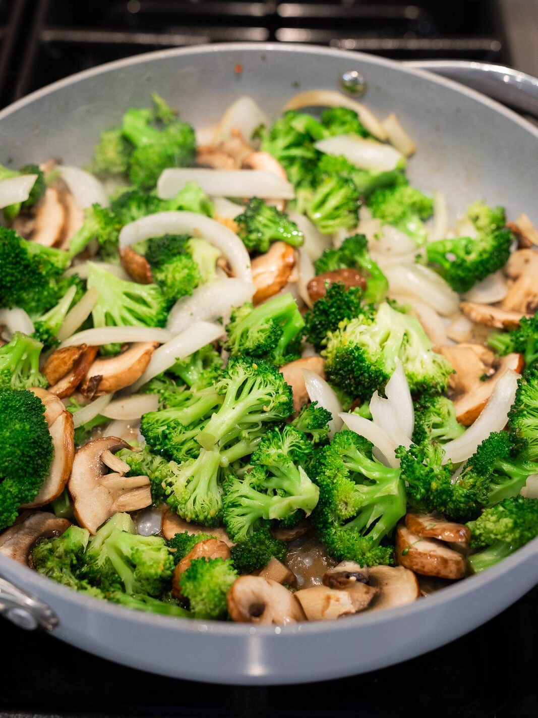sauteing broccoli, mushrooms and onions in a skillet
