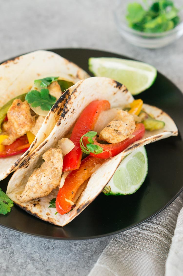 baked chicken fajitas in tortillas on a plate