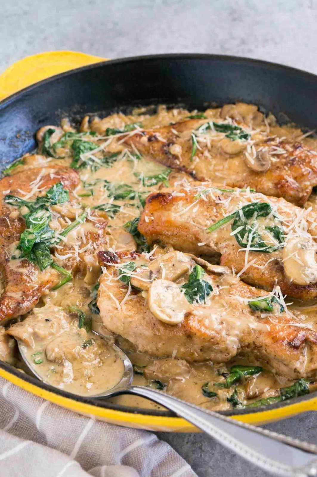 spooning mushroom sauce over chicken