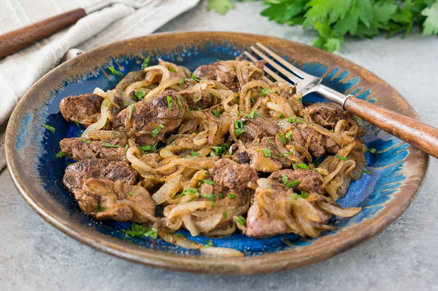 livers and onions on a blue plate