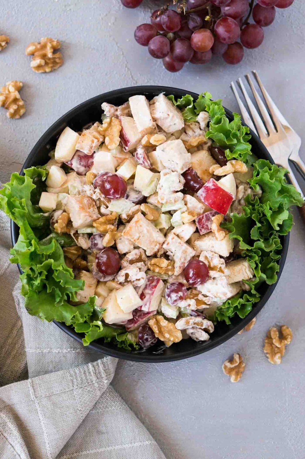 chicken waldorf salad over lettuce in a black bowl