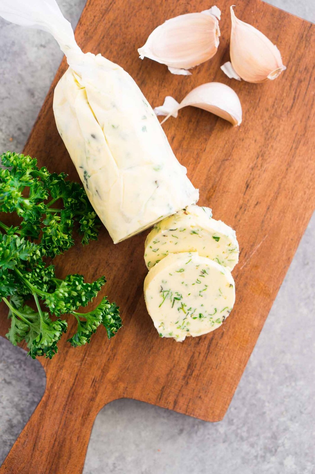 wrapped compound butter in parchment paper on a board