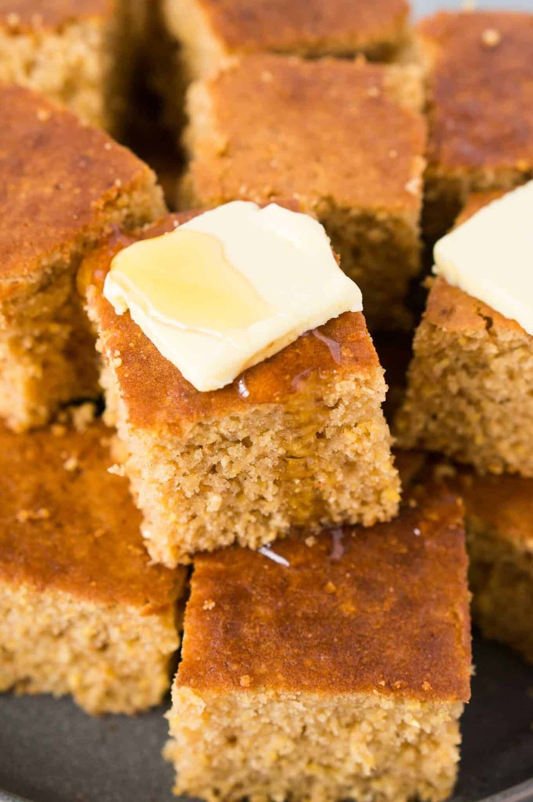 close up image of cornbread piece with butter