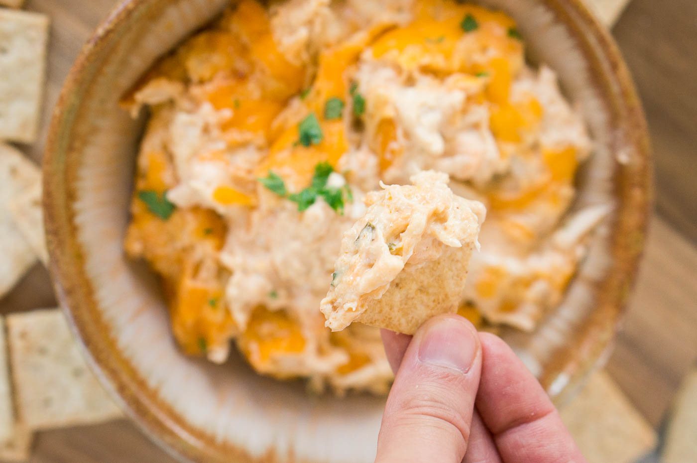 close up image of dipping cracker in a dip