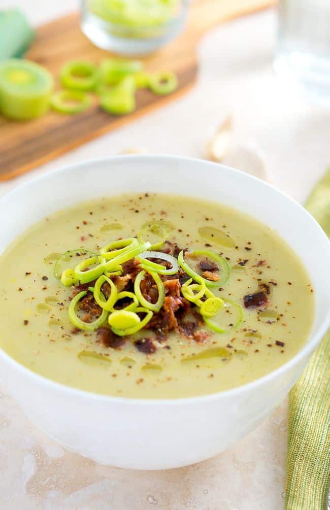 Creamy Potato and Leek Soup topped with bacon and leeks