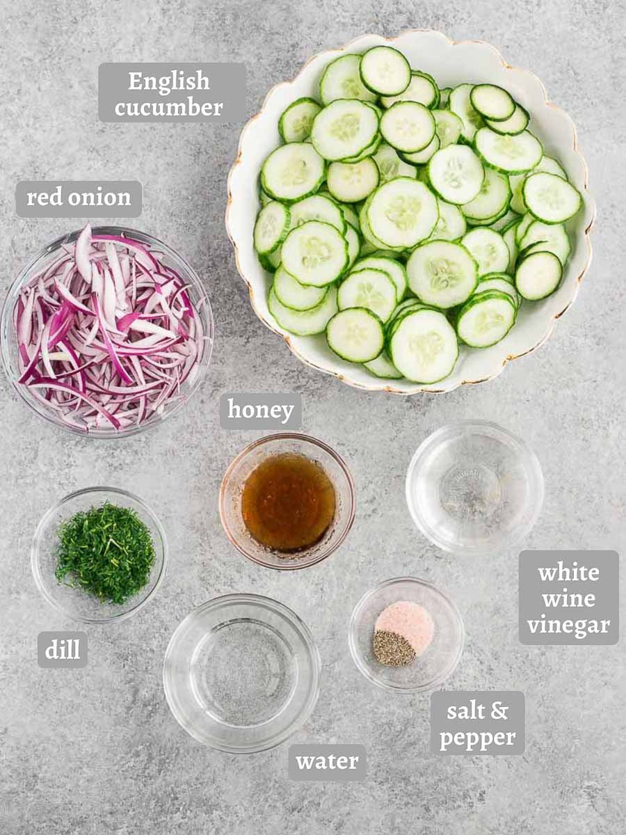cucumbers red onion and dressing ingredients on a board