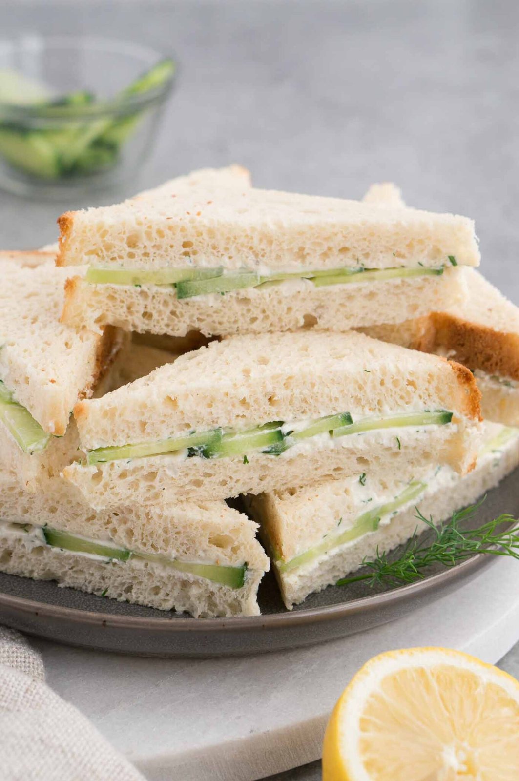 cucumber sandwiches stacked on a plate