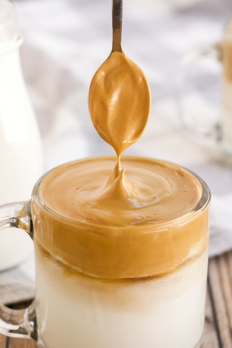 close up of whipped dalgona coffee in a clear mug