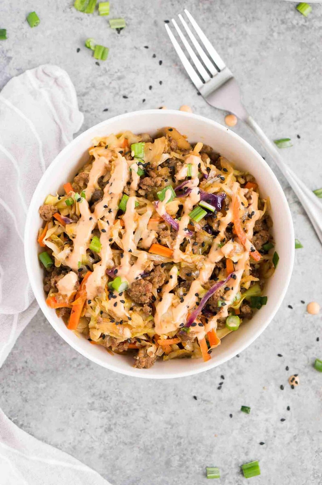 deconstructed egg roll in a bowl with sriracha sauce