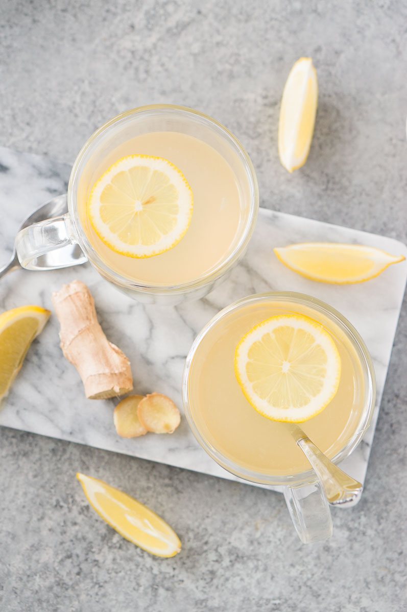 two ginger lemon tea with lemon slices in glass mugs