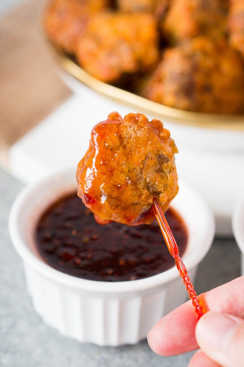 dipping sausage ball in a raspberry chili dip
