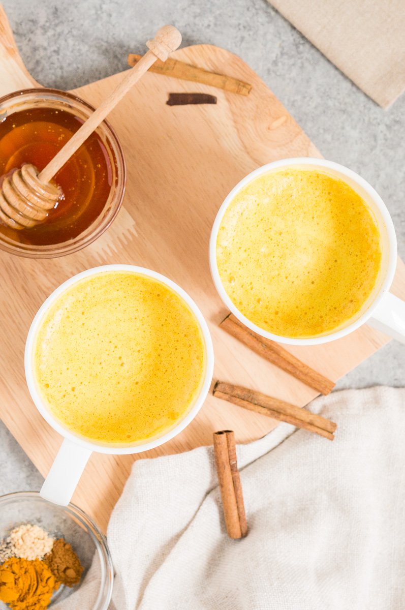mugs with golden milk latte with turmeric and spices