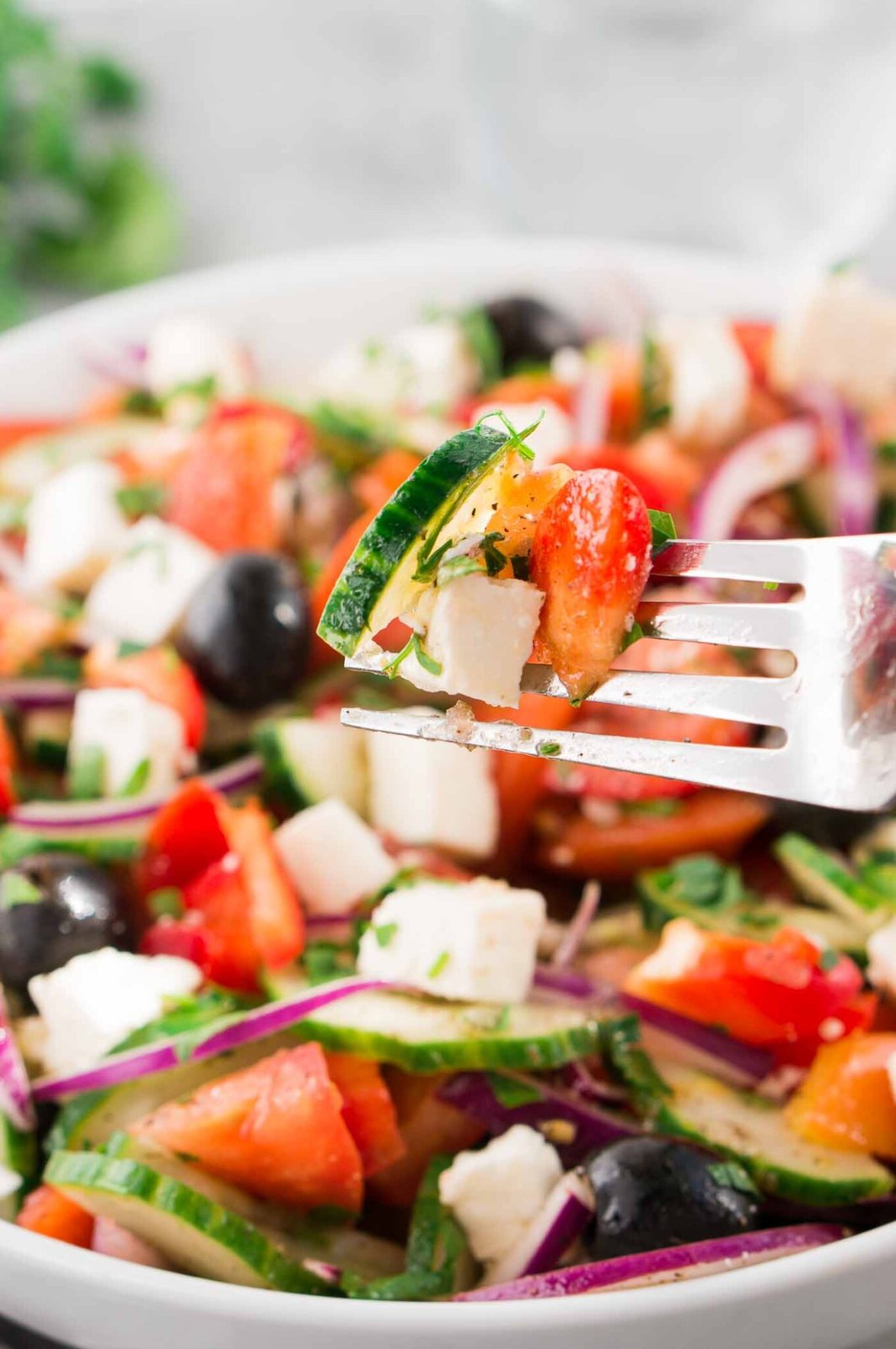 taking a bite of a tomato and cucumber salad