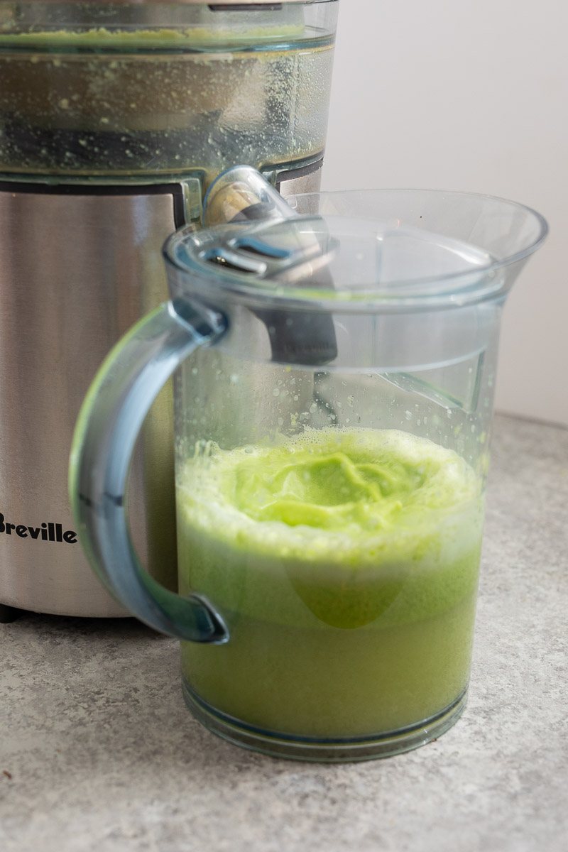 juicing green juice from cucumber, celery, apple, lemon, ginger, parsley