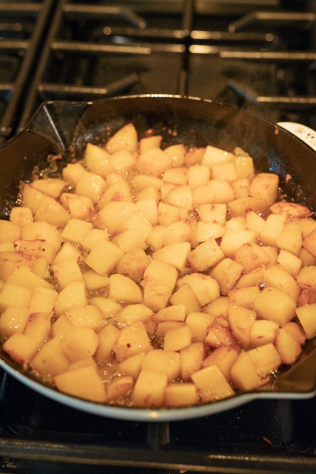 cooking chopped potatoes in a skillet