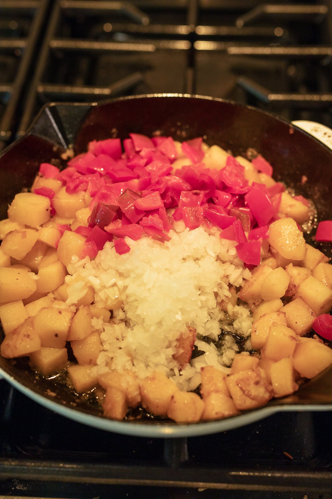 cooking potatoes and vegetables in a skillet