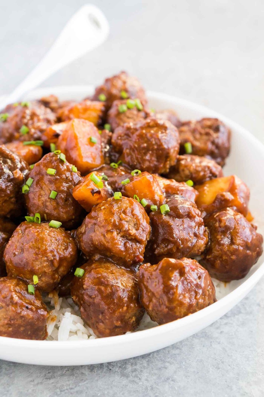 hawaiian meatballs served over rice in a bowl