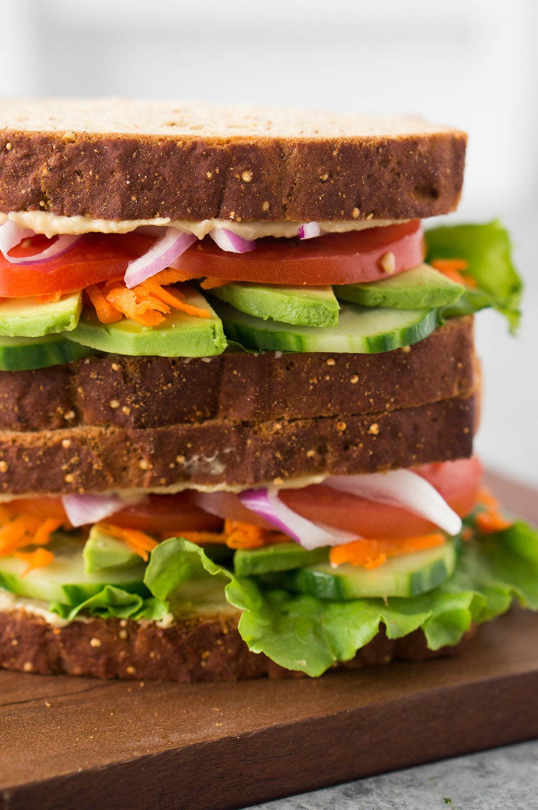 stacked vegetable sandwich on a wooden board