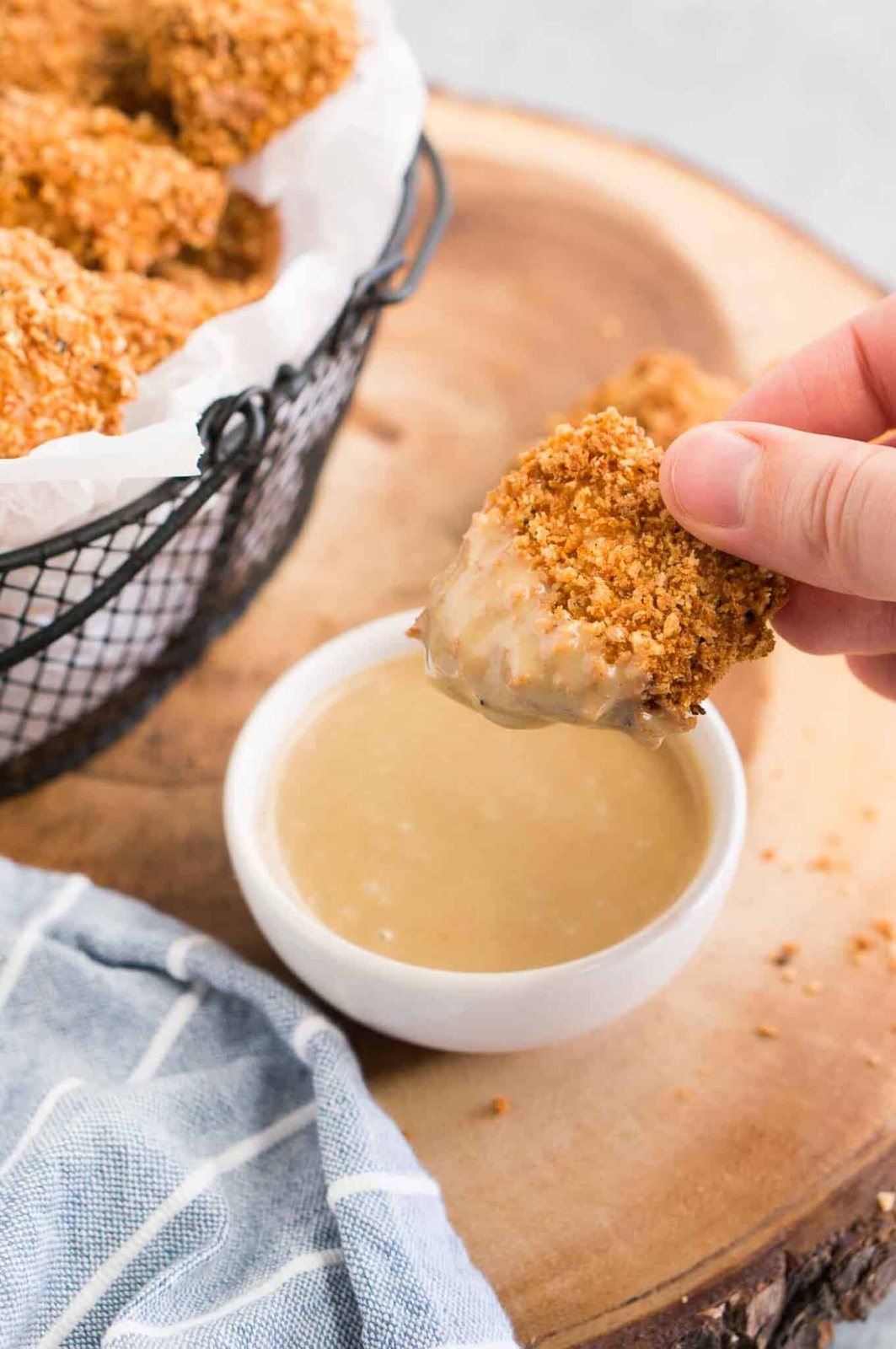 dipping a chicken nugget in a honey mustard sauce