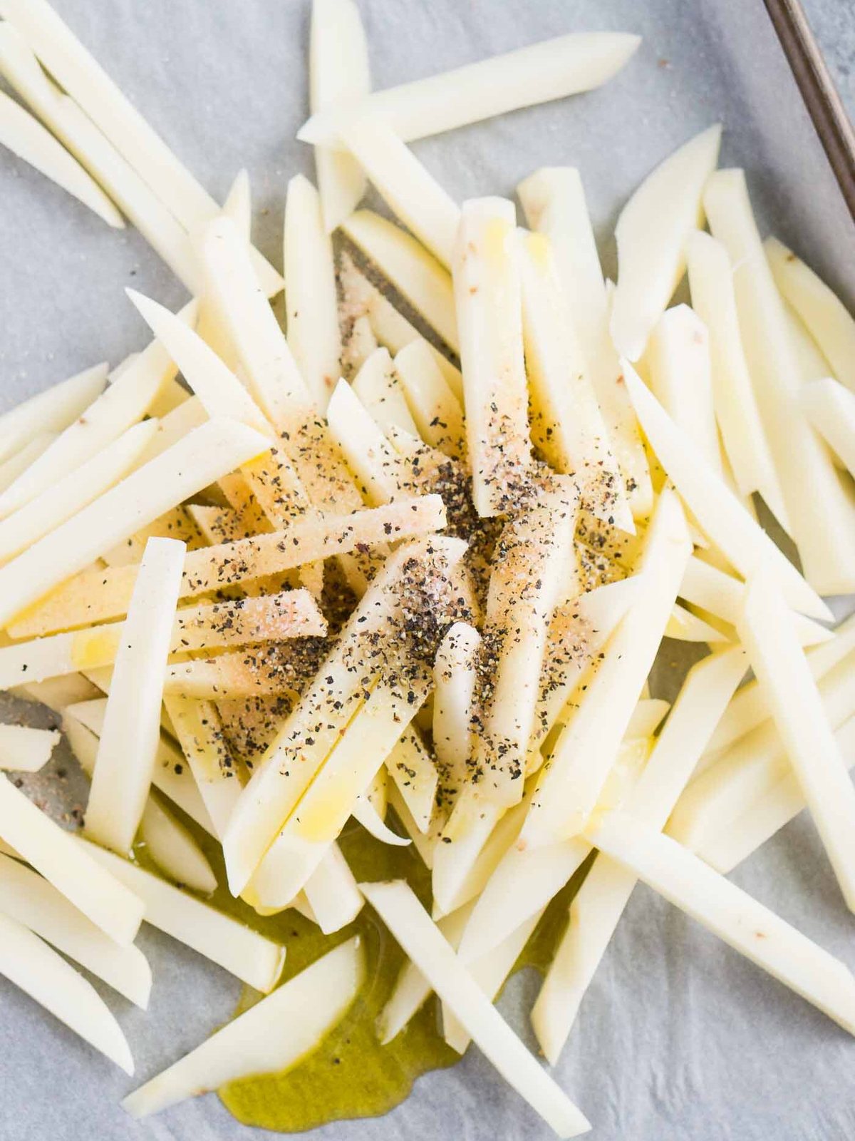 seasoned potato fries on a baking sheet