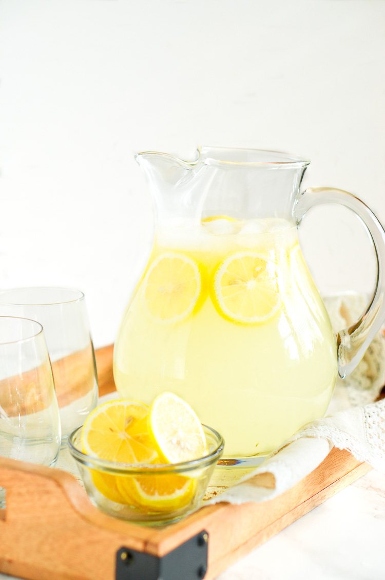 homemade lemonade in a glass pitcher with lemons