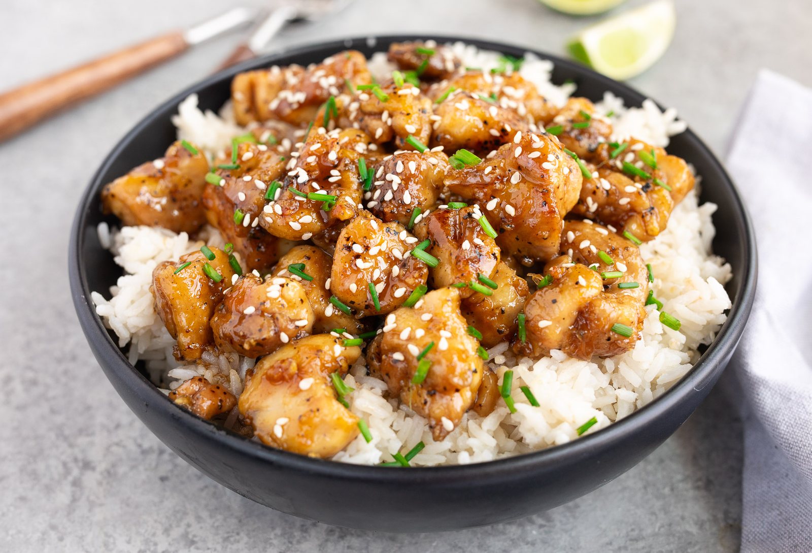 honey garlic chicken served over rice in a black bowl