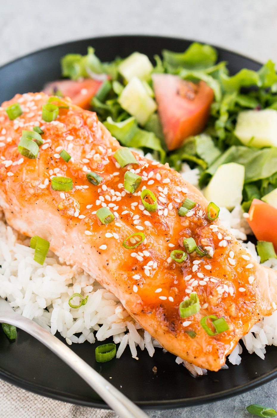 close up of honey sriracha glazed salmon over rice