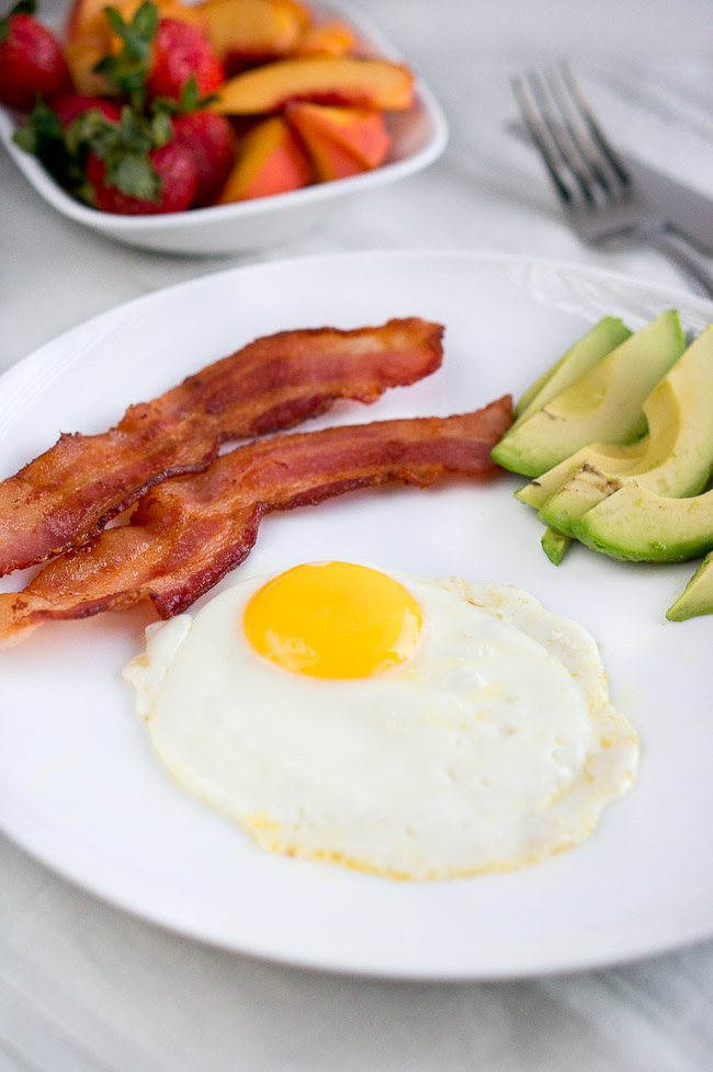 Oven Baked Bacon with a fried egg and avocado on a plate