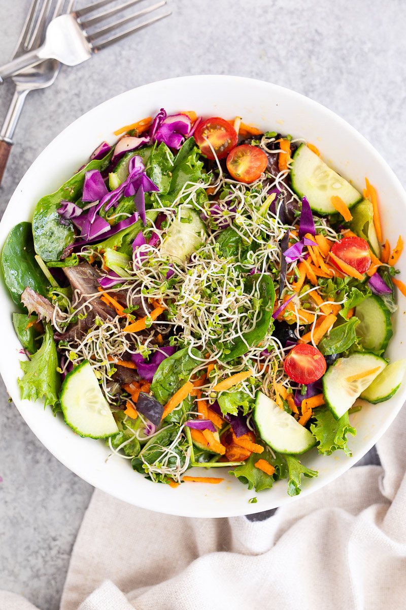 giant salad topped with broccoli sprouts