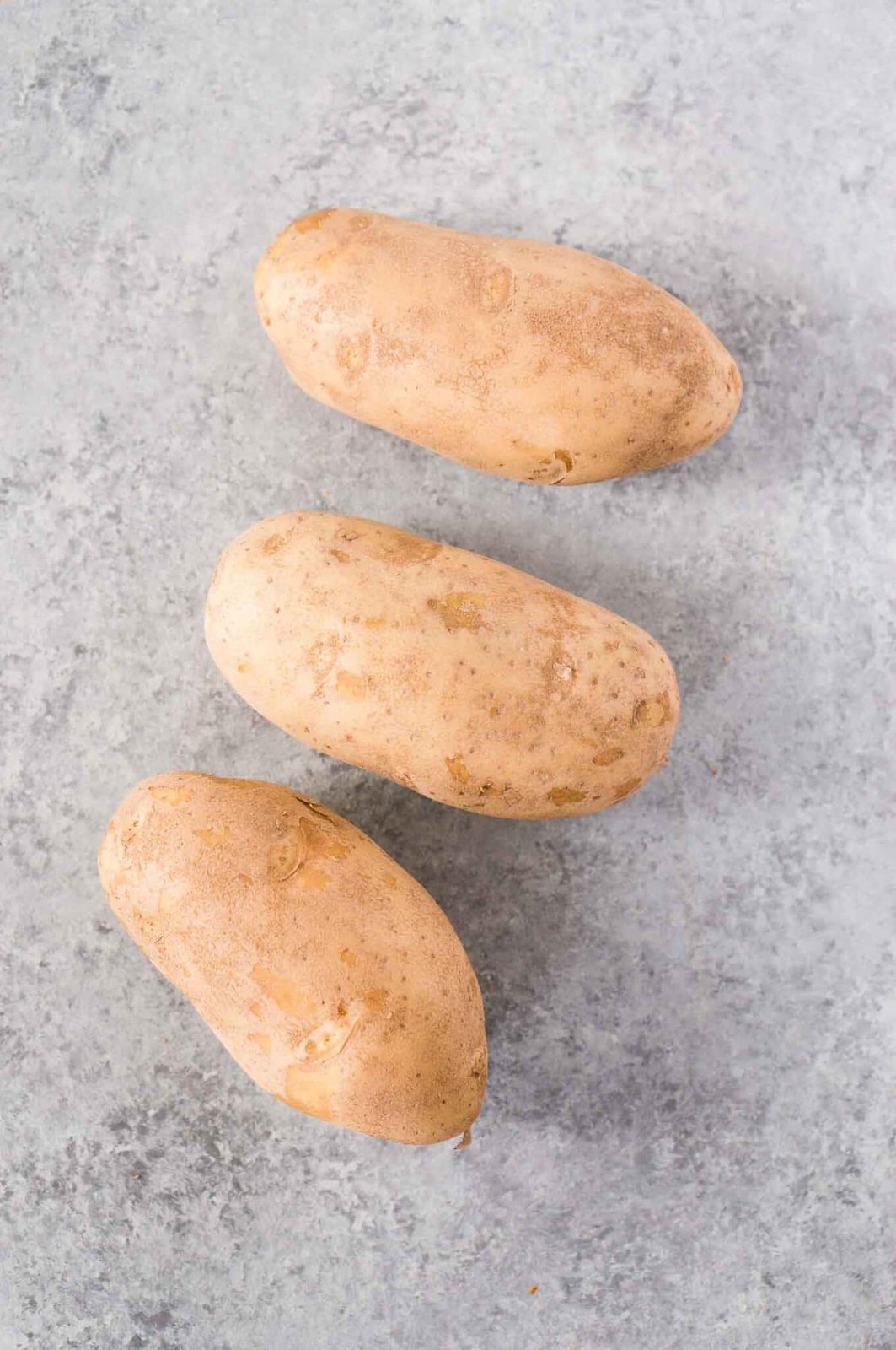 Russet potatoes on a board