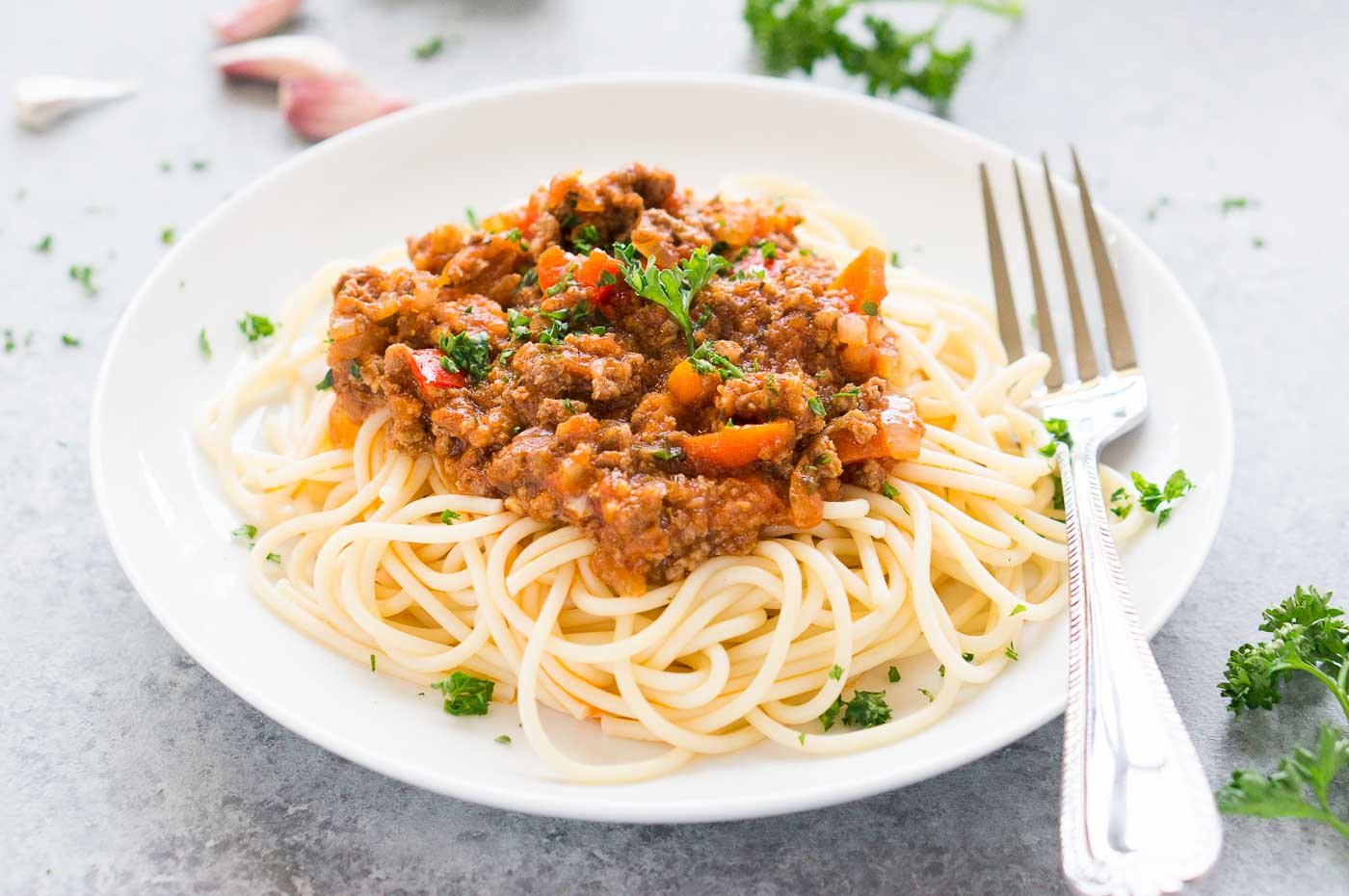 close up image of Bolognese sauce over spaghetti
