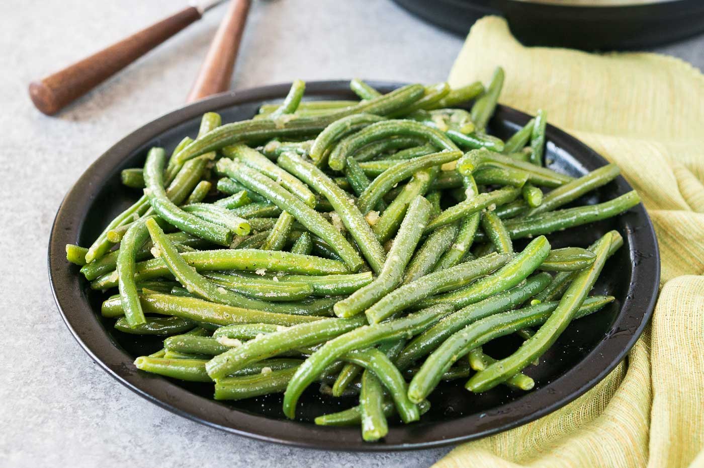 close up image of seasoned cooked green beans on a plate