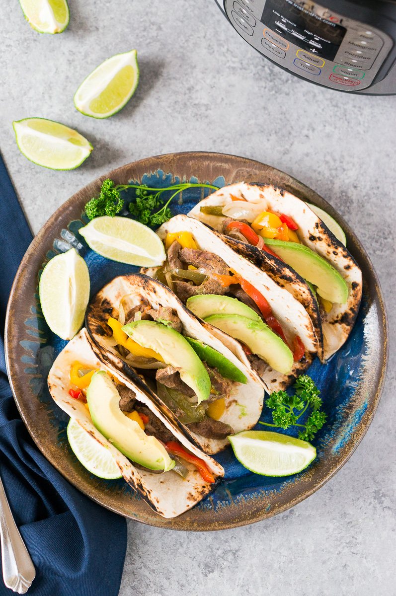 steak fajitas on a plate next to instant pot
