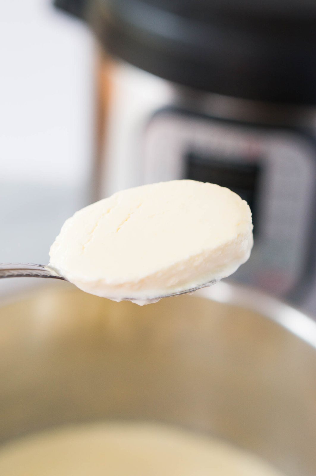 scooping a spoonful of homemade yogurt in the instant pot