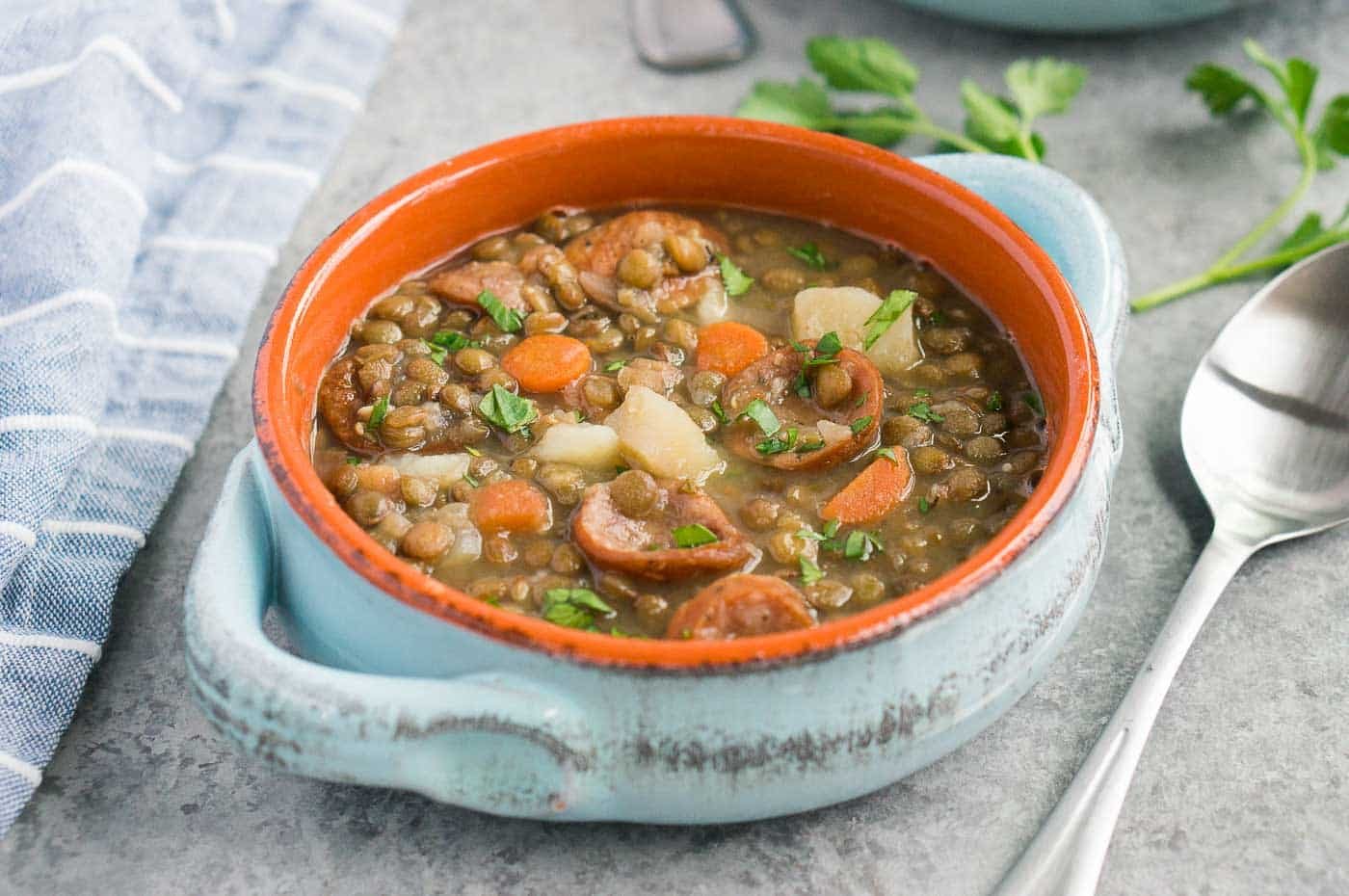 close up image of lentil soup in a clay bowl