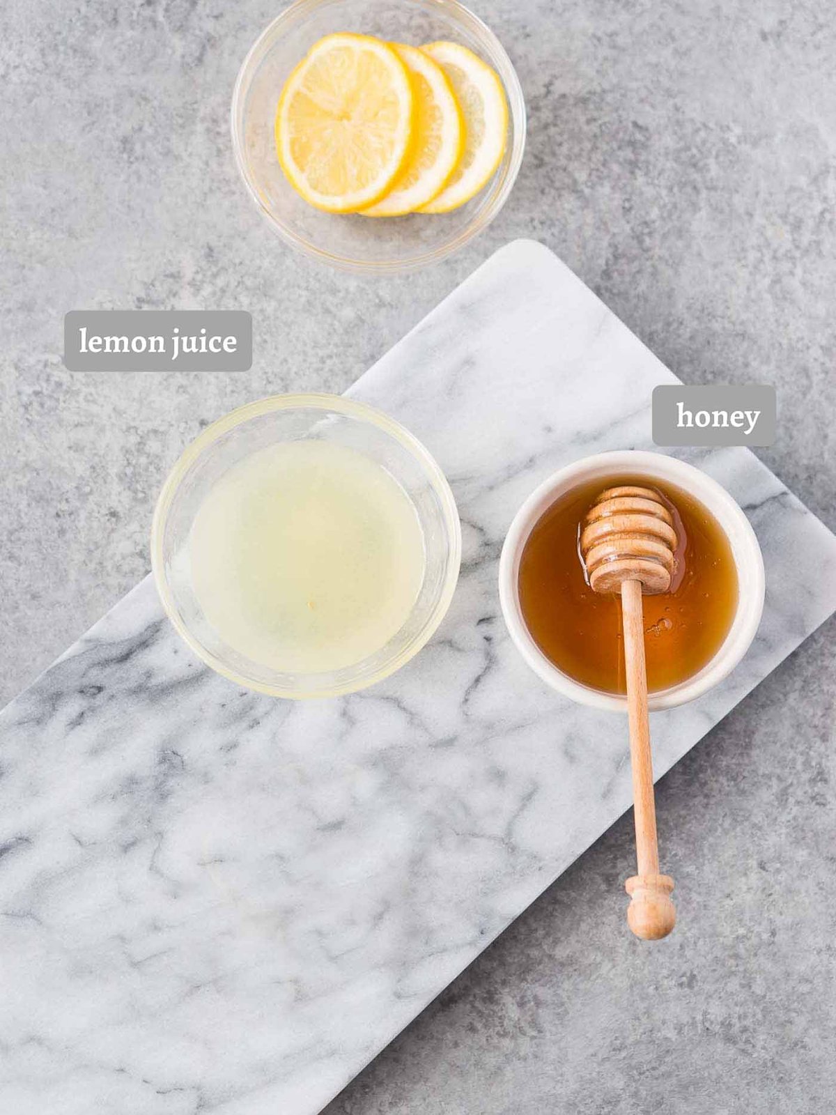 lemon juice honey and lemon slices on a board